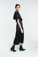 Black midi a-lined dress with o-logo made from recycled viscose.  Rubber band waist and t-shirt sleeves. Worn by a model showing the dress. Hálo from north