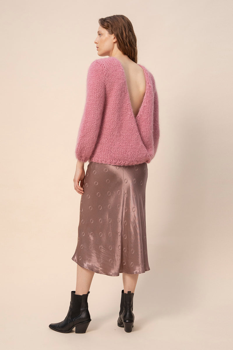 Huurre handknitted wrapknit in mauve worn backwards. Model is wearing the knit and taupe o-logo skirt.  Hálo from north