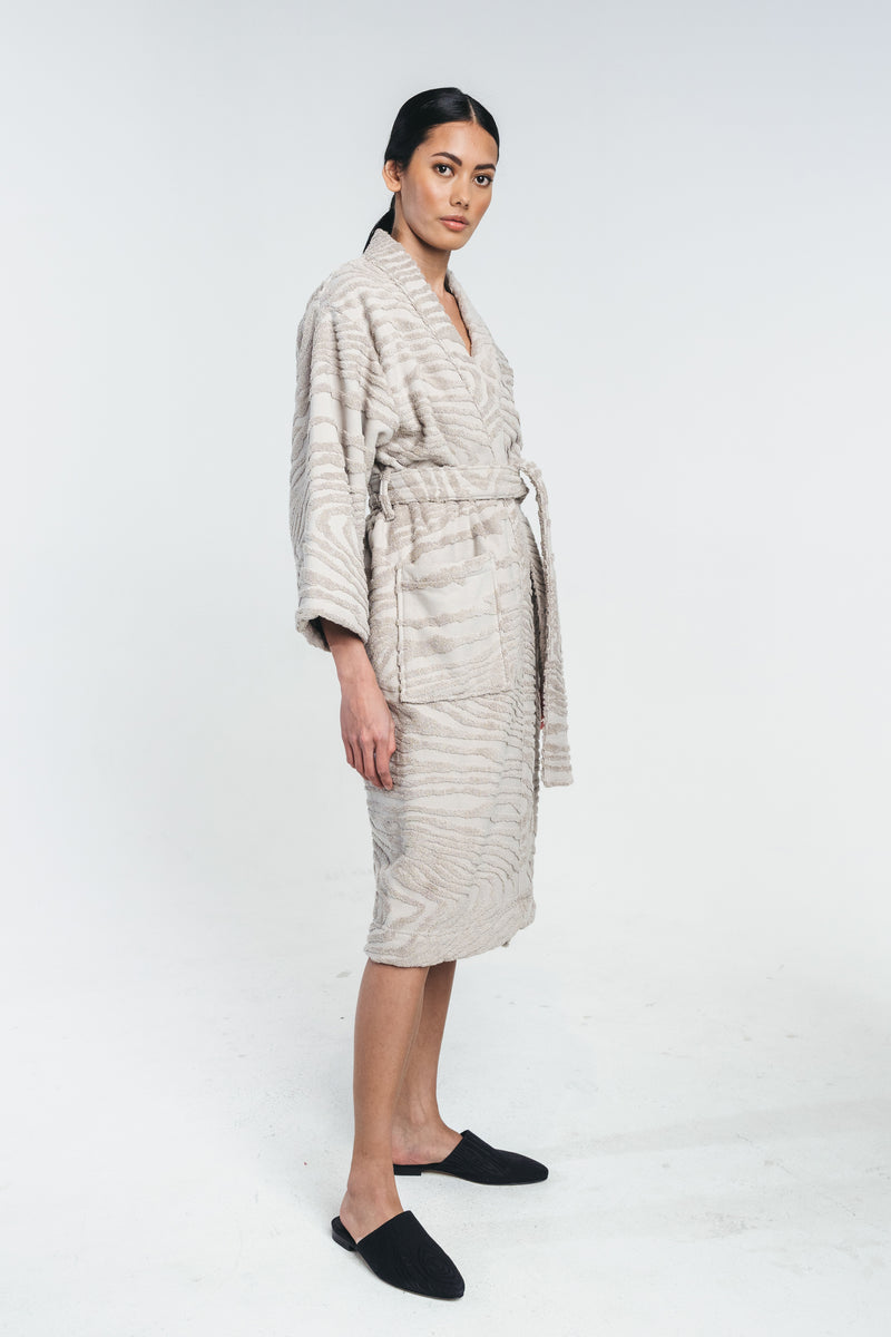 Kaarna bathrobe in sand worn by a model. Matched with kaarna slippers. Picture from the side. Hálo from north