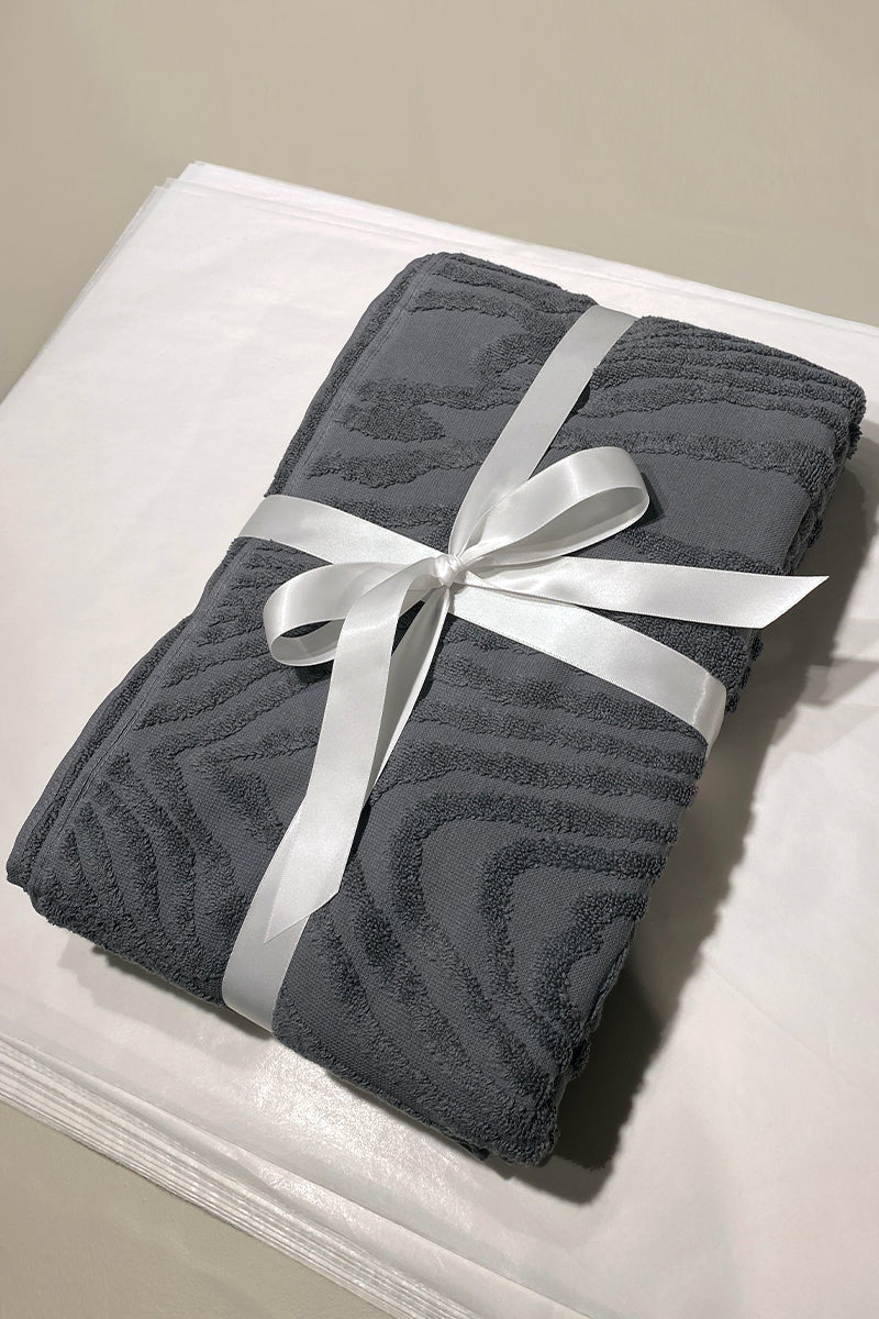Kaarna bath towel in grey folded and wrapped with white ribbon. Perfect gift. Hálo from north