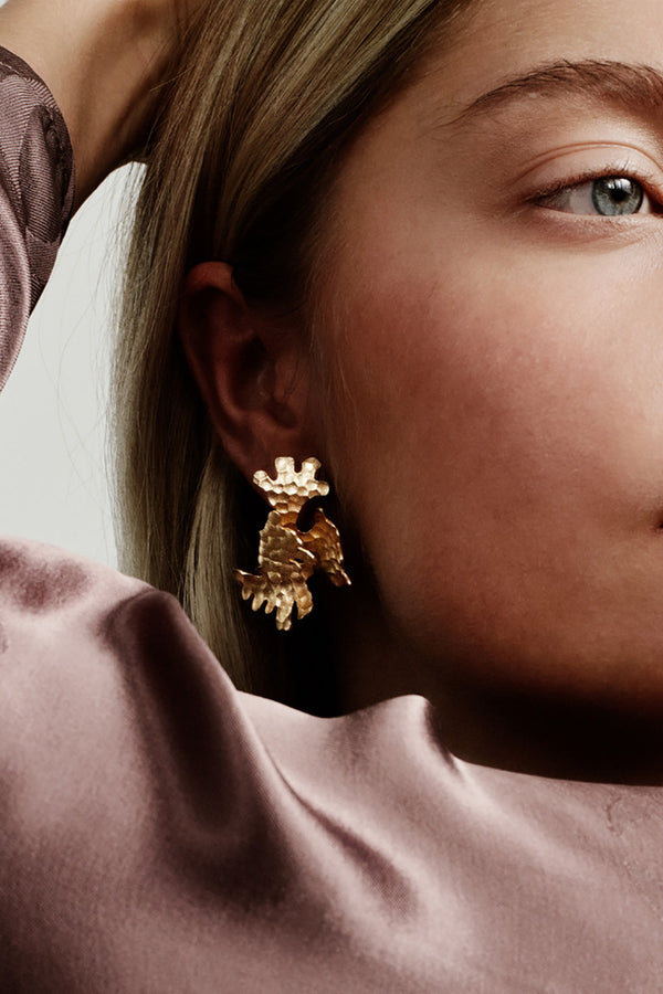 Tundra earrings in bronze worn by a model. Exclusive Kalevala x hálo collaboration. Hálo from north