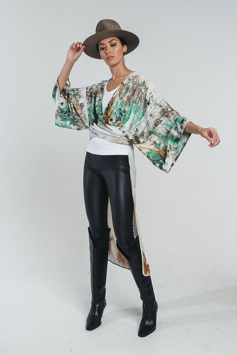 Reidar prairie knotted kimono in earthy tones tied around waist and paired with white top, hat and black leather pants. Hálo x Reidar Särestöniemi EXCLUSIVE