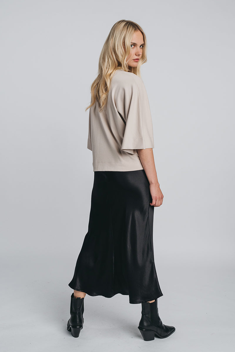 Tundra box shirt in sand paired with kajo slip skirt in black. Picture from behind. Hálo from north