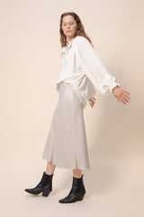 Tundra prairie blouse in natural white worn together with light colored slip skirt. Side picture. Hálo from north