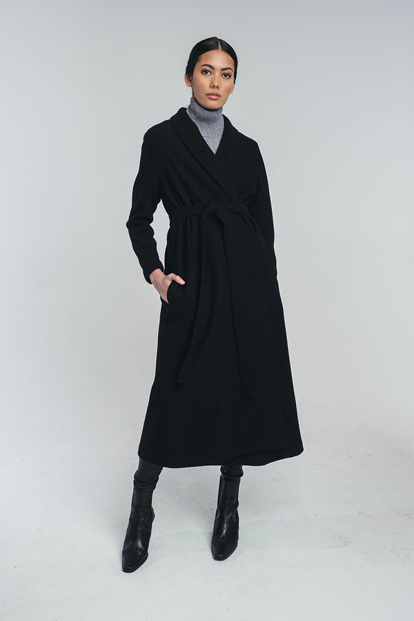 Tundra woolen coat in black paired with grey turtleneck shirt. The coat i stied from the waist with matching belt. Hálo from north